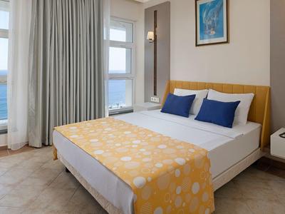 Camera d'hotel moderna con letto grande, vista mare e arredamento minimalista.