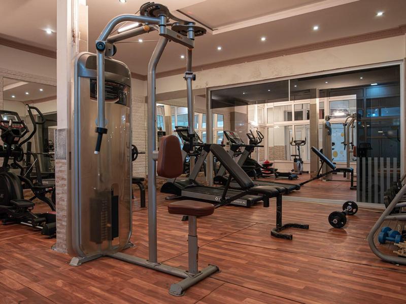 Équipements de gym modernes dans une salle de sport d'hôtel avec sol en bois.