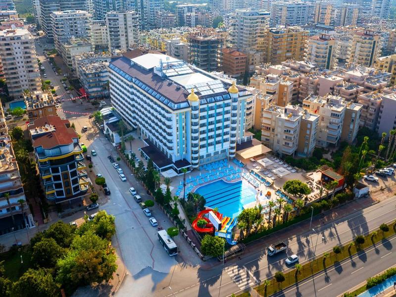 Grand hôtel avec piscine extérieure au milieu d'une zone urbaine dense.