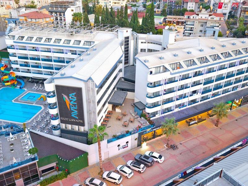 Grande hotel con piscina e parcheggi in un ambiente urbano alla luce del giorno