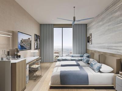 Modern hotel room with two beds, desk, and city view.