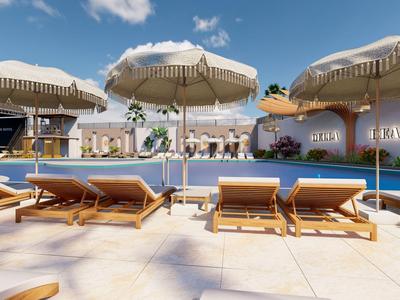 Poolbereich mit Sonnenschirmen, Liegestühlen und klar blauem Himmel in einem Hotel.