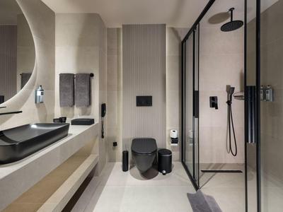 Moderní koupelna s černou toaletou, dvěma umyvadly a sprchovým koutem.