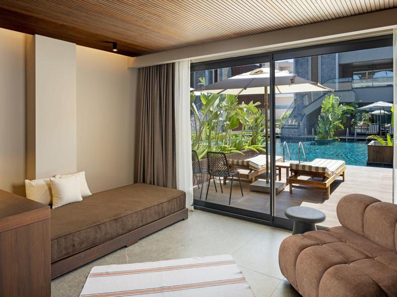 Prostorná hotelová hala s moderním nábytkem a vlnitými dřevěnými stropy.