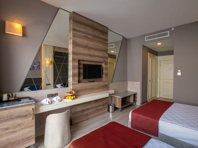 Modernes Hotelzimmer mit zwei Betten, Holzlattenwand und großem Spiegel an der Wand.