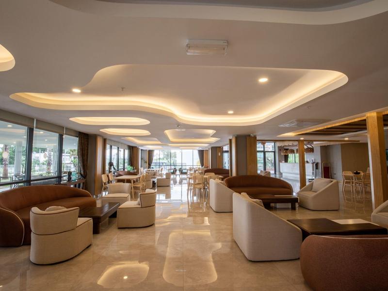 Espace lounge d'hôtel moderne et spacieux avec fauteuils élégants et éclairage doux.