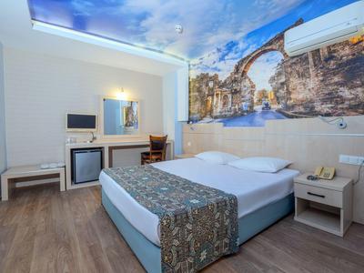 Chambre d'hôtel moderne avec lit double, fresque murale et sol en bois