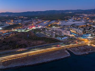 Vista di una città illuminata con strade e acqua al crepuscolo.