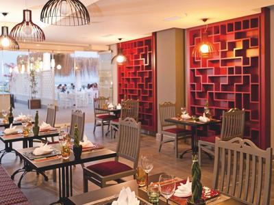 Modernes Restaurant mit Holztischen, bequemen Stühlen und stilvollen Hängelampen in warmem Licht.