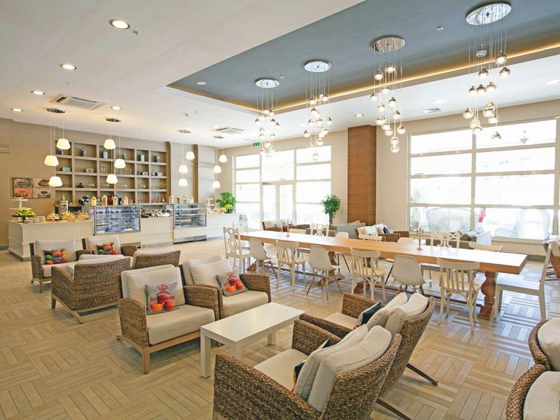 Lichte lounge met comfortabele banken, fauteuils en grote ramen voor natuurlijk licht.