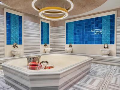 Luksusowa kwadratowa wanna z płytkami na ścianach w nowoczesnej łazience.