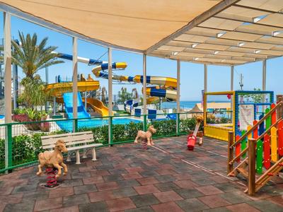 Zewnętrzny plac zabaw z kolorowymi zjeżdżalniami wodnymi i konstrukcjami pod dachem.