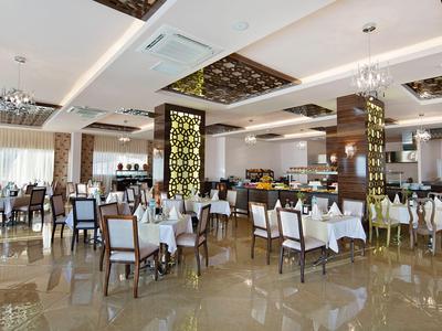 Restaurant lumineux et moderne avec nappes blanches et chaises confortables dans un hôtel.