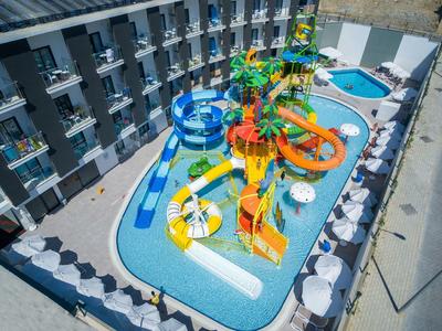 Vista di un hotel con un parco acquatico colorato e diverse scivoli nel cortile.