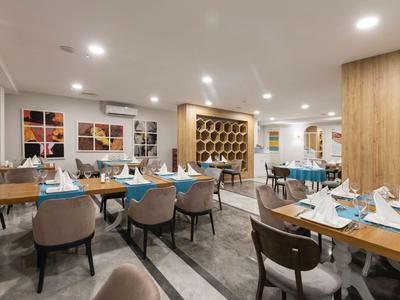 Restaurante moderno con manteles azules, sillas marrones y mesas preparadas con iluminación cálida.