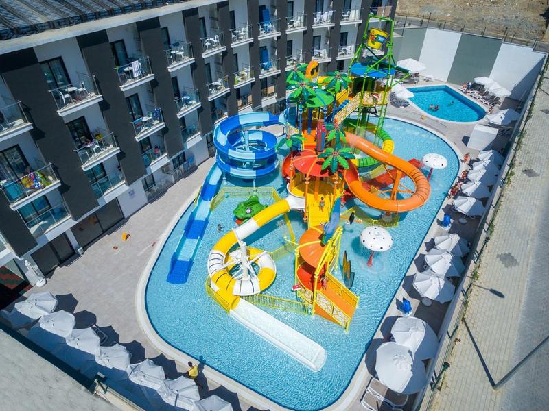 Vista di un hotel con un parco acquatico colorato e diverse scivoli nel cortile.