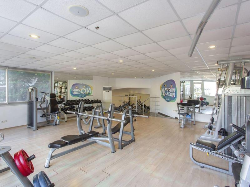 Palestra luminosa con attrezzature moderne e ampie finestre.