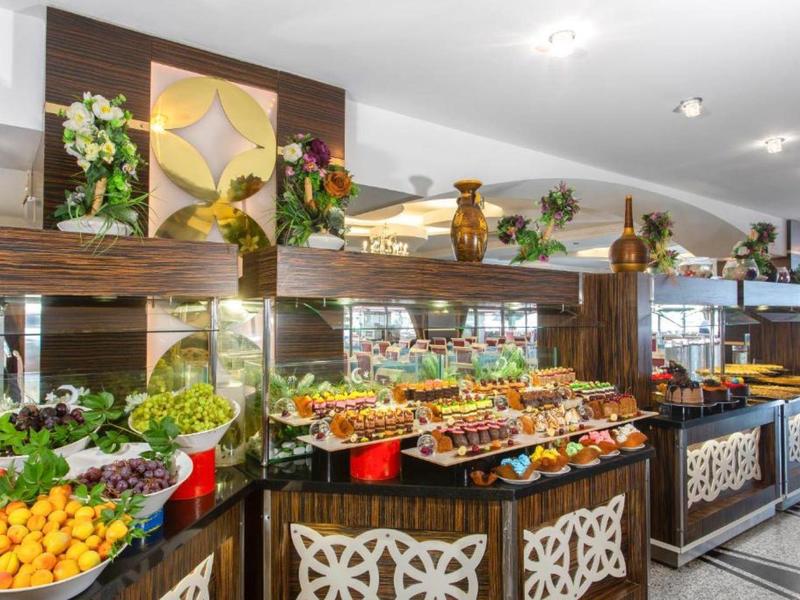 Buffet colorato di frutta e bevande in un ambiente alberghiero moderno.