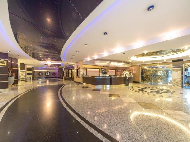 Ampia hall di un hotel con pavimento lucido e illuminazione elegante.