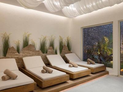 Espace détente moderne avec des fauteuils confortables et des plantes décoratives près de grandes fenêtres.