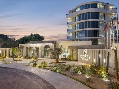 Modernes, mehrstöckiges Gebäude mit Glasfassade, davor beleuchteter Garten und geschwungener Gartenweg.