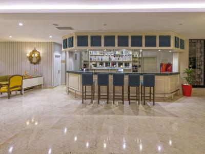 Nowoczesny bar hotelowy z hokerami i eleganckim miejscem do siedzenia w jasnym otoczeniu.