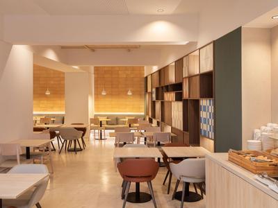 Modernly furnished dining area with tables, chairs, and a buffet section.