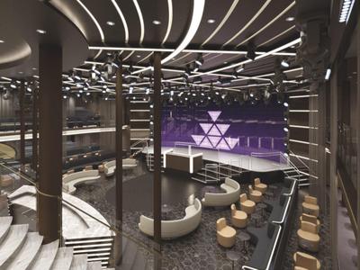 Moderní hotelová lobby s zakřiveným schodištěm, posezením a nápadným stropním osvětlením.