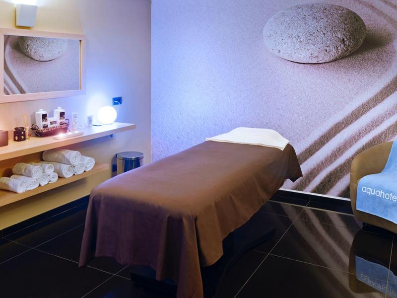 Relaxing spa room with massage table, soft lighting, and gentle wall art.