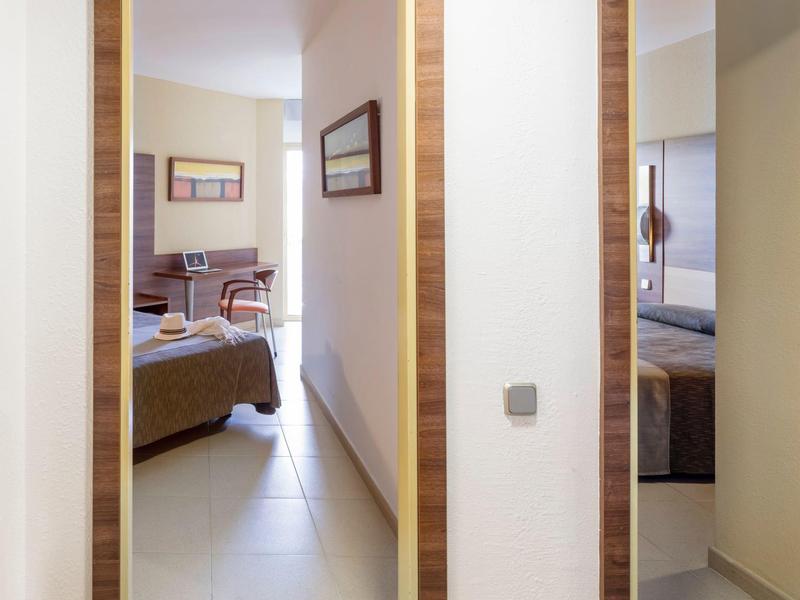 Flur mit zwei Türen, Blick in zwei unterschiedliche Schlafzimmer mit hellen Wänden und Möbeln.