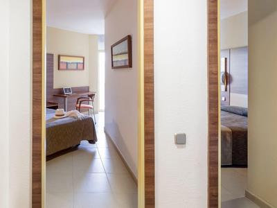 Flur mit zwei Türen, Blick in zwei unterschiedliche Schlafzimmer mit hellen Wänden und Möbeln.