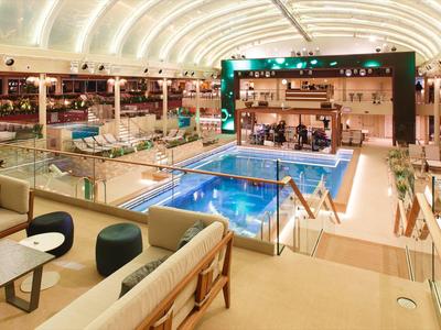 Area piscina interna di lusso con posti a sedere e atmosfera moderna in un hotel.