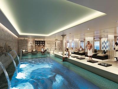 Luxuriöser Spa-Bereich mit Innenpool, Wasserfällen und entspannenden Liegen.