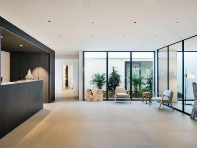 Modern hotel lobby with large windows, minimalist decor, and seating areas.