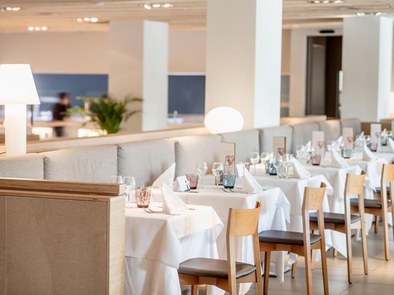 Bright, elegant hotel dining area with neatly arranged tables and modern décor.