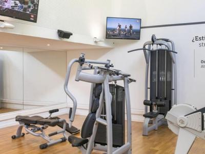 Palestra moderna con varie attrezzature per l'allenamento e specchi sulle pareti.