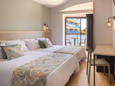 Gemütliches Hotelzimmer mit zwei Einzelbetten und Balkon mit Blick aufs Meer.