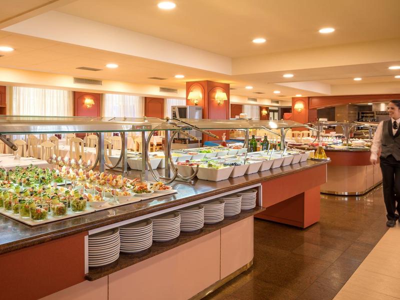 Bufet s různými jídly a číšník v restauraci.