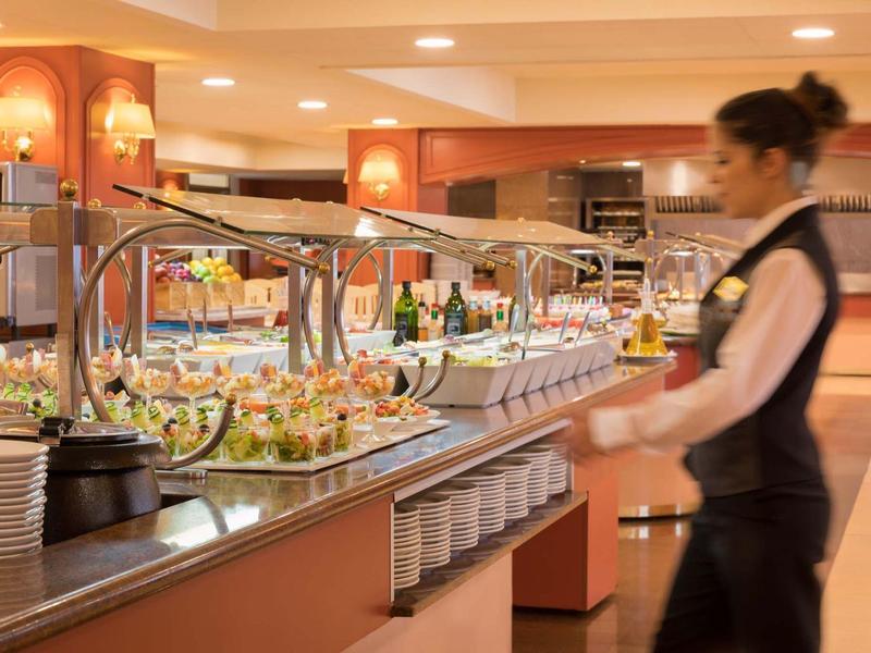 Moderní samoobslužný bufet s jemným osvětlením v hotelové restauraci.