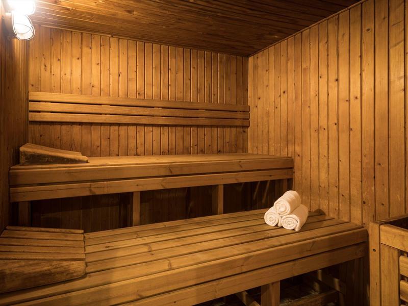 Traditionelle Sauna mit Holzbänken und zwei weißen Handtüchern.