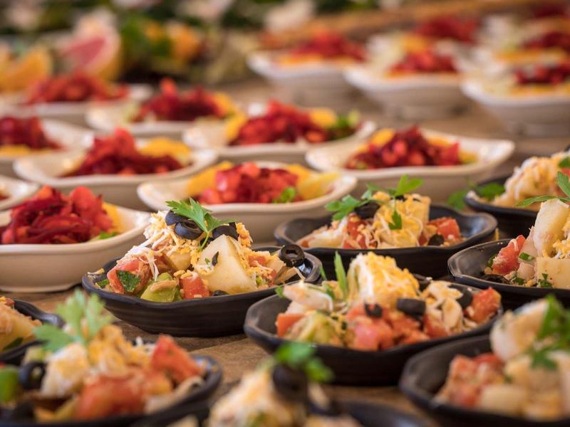 Mehrere Teller mit bunten Vorspeisen, angerichtet auf einem Tisch.