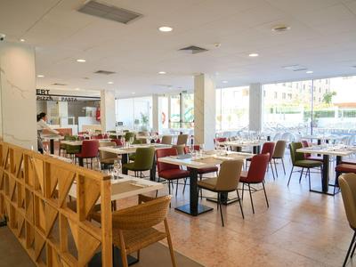 Helles, modernes Restaurant mit Sitzbereich, Holzwänden und großen Fenstern.