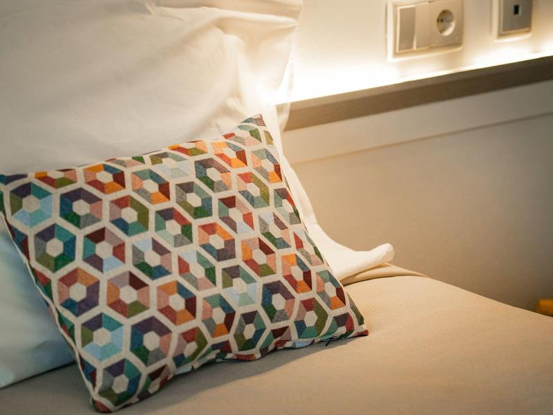 Federa colorata con motivo su un letto ospedaliero bianco in una stanza per pazienti.