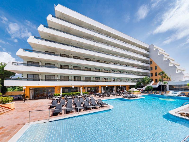 Modern hotel met meerlaags ontwerp en groot buitenzwembad met ligstoelen.