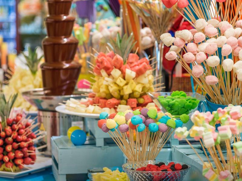 Kleurrijke snoepjes en chocoladefonteinen op een buffet op een vakantiebestemming.