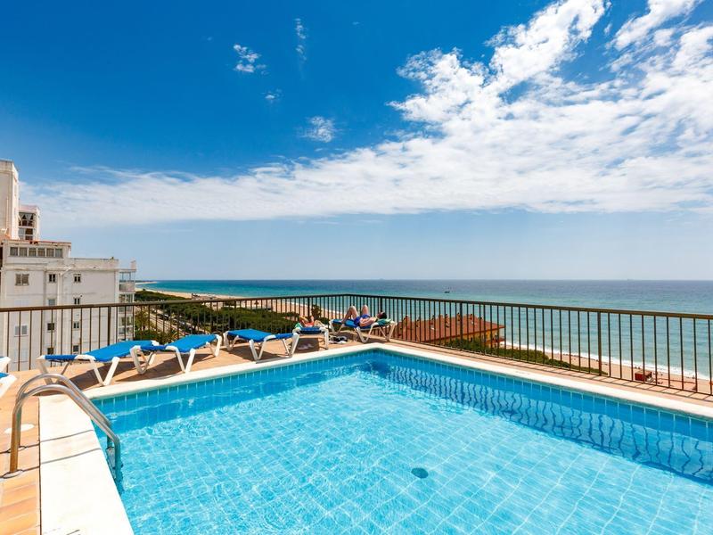 Zwembad op een dakterras met uitzicht op de zee op een zonnige dag.