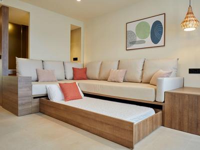 Bright living room with pull-out sofa, modern wood paneling, and decorative wall art.