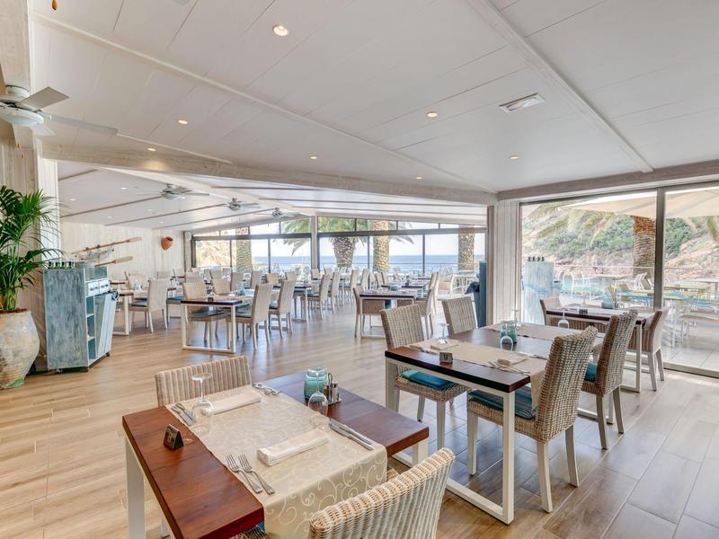 Modern, cozy restaurant with wooden floors and large windows offering a view.