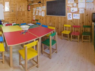 Kleurrijk klaslokaal met kindermeubilair en leermaterialen aan de muren