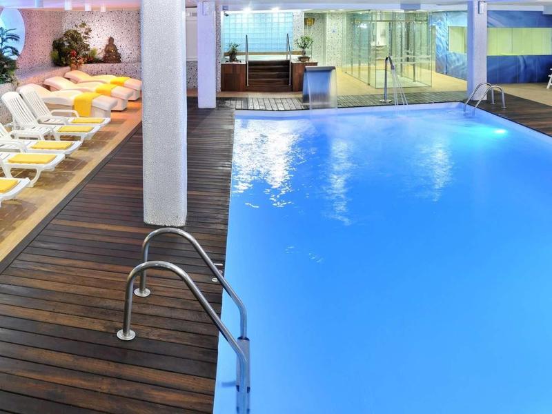 Binnenzwembad met ligstoelen en moderne sfeer in een hotel